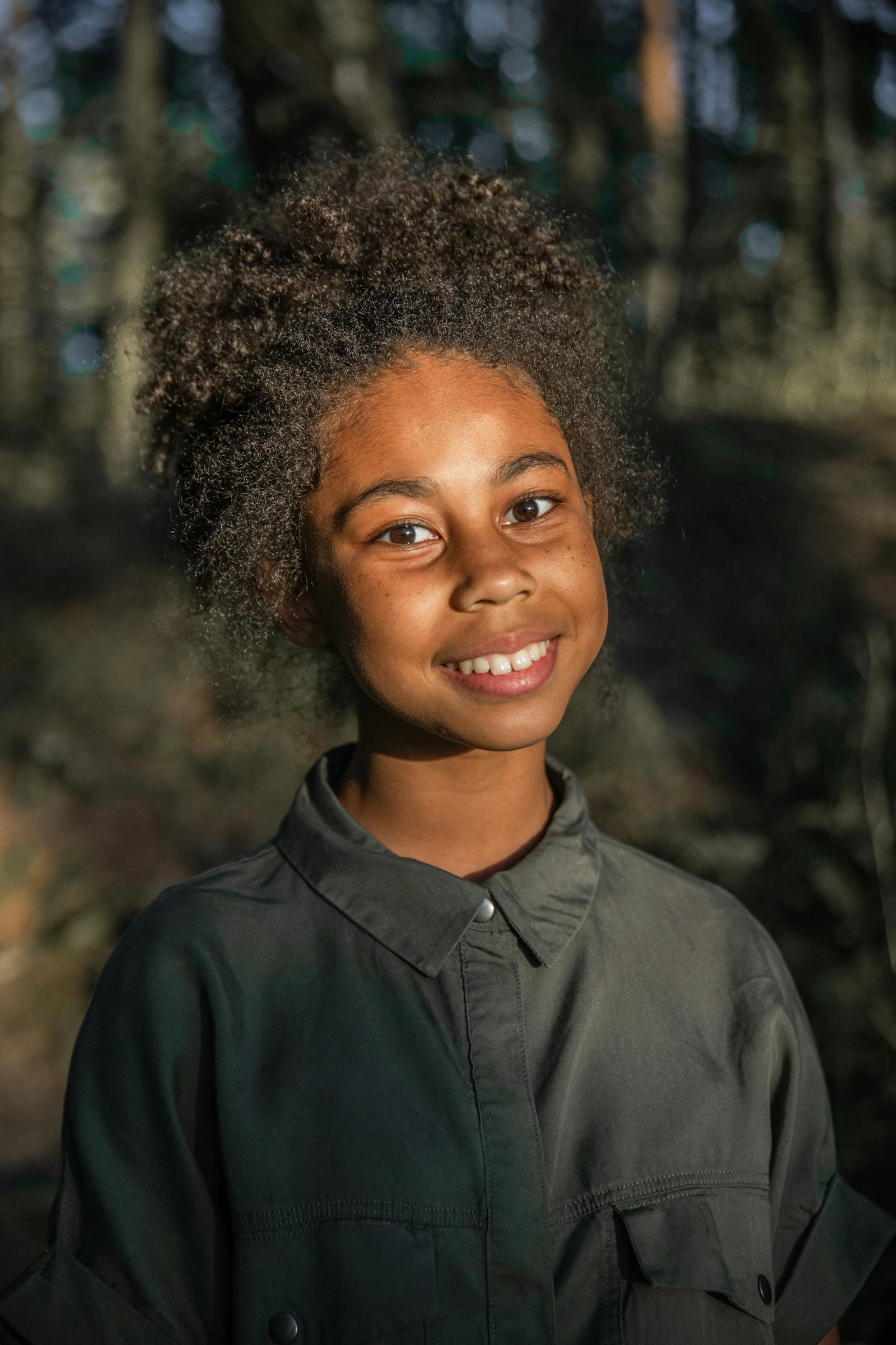 A young child smiling in soft natural light.