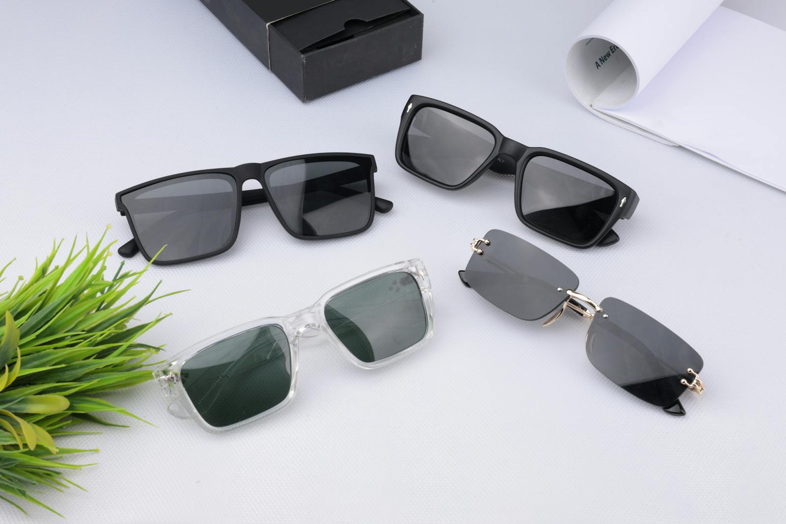 Several pairs of sunglasses laid out on a light surface.